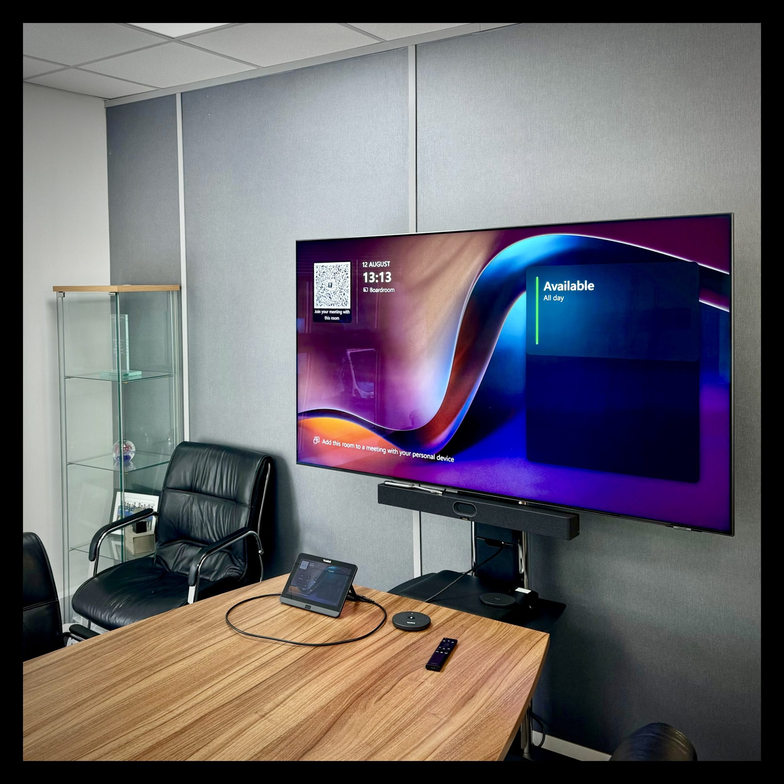 a meeting room fitted with a microsoft teams room device for business video conferencing