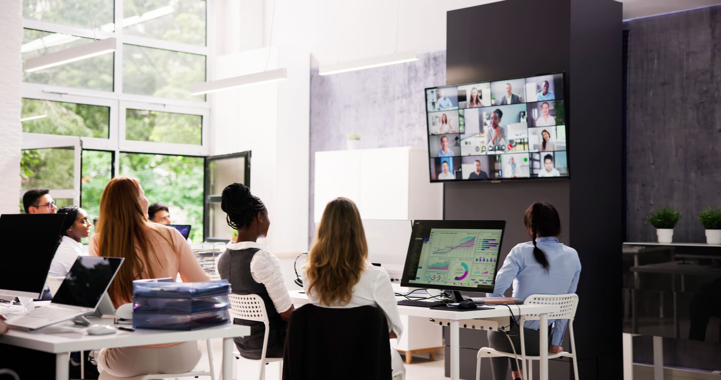 a group of employees looking at a video conferencing tv set up